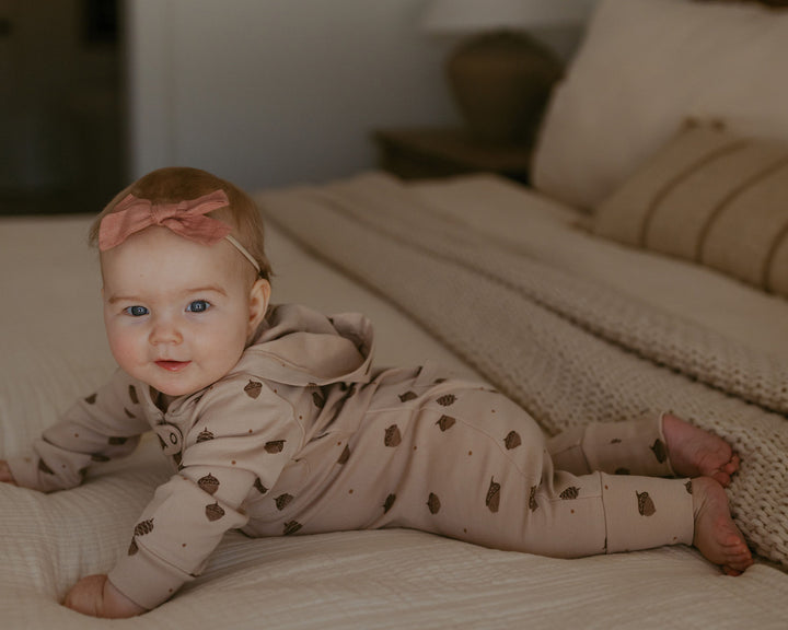 Child wearing Organic Hooded Zipper Romper in Little Acorn.