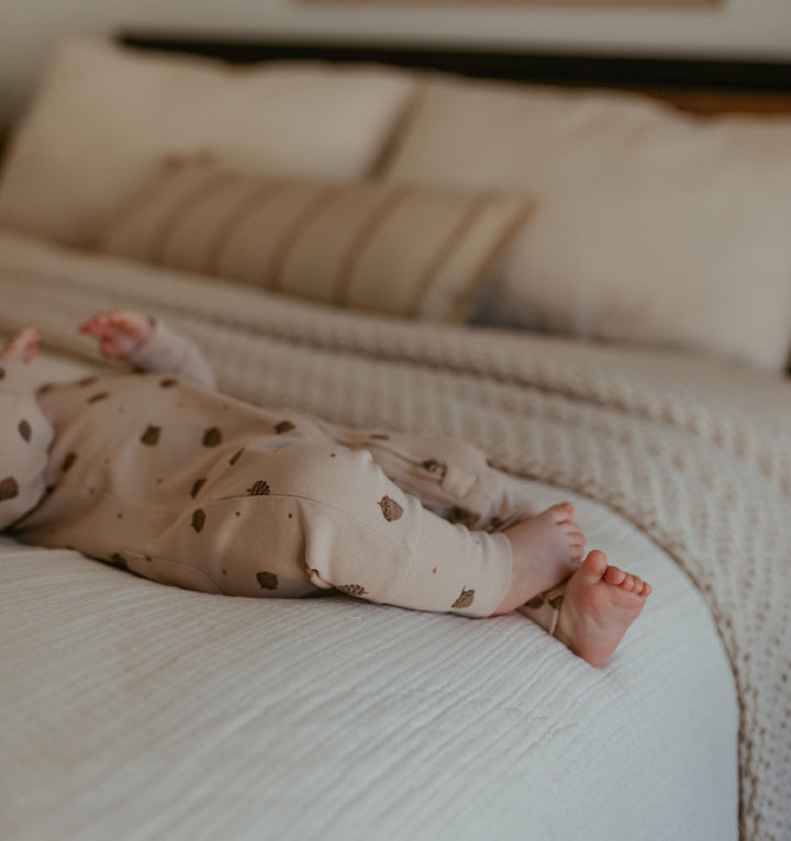 Child wearing Organic Hooded Zipper Romper in Little Acorn.