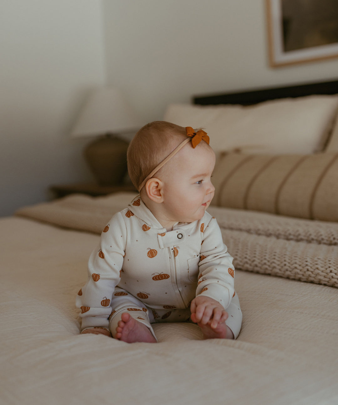 Child wearing Organic Hooded Zipper Romper in Pumpkin Spice.