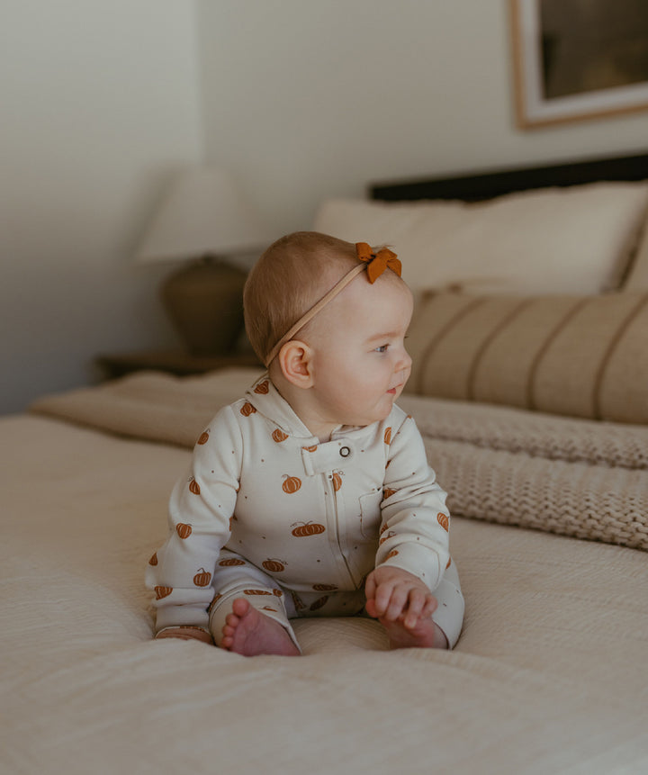 Child wearing Organic Hooded Zipper Romper in Pumpkin Spice.
