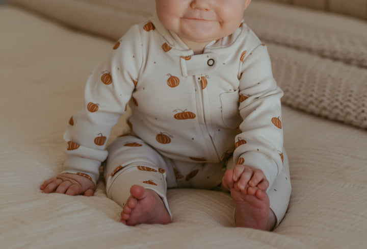 Child wearing Organic Hooded Zipper Romper in Pumpkin Spice.