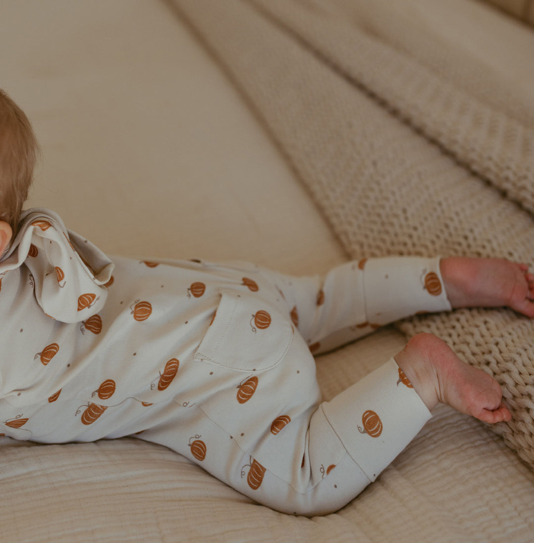Child wearing Organic Hooded Zipper Romper in Pumpkin Spice.