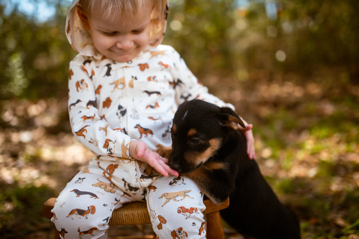 Child wearing Organic Hooded Zipper Romper in Puppy Love.