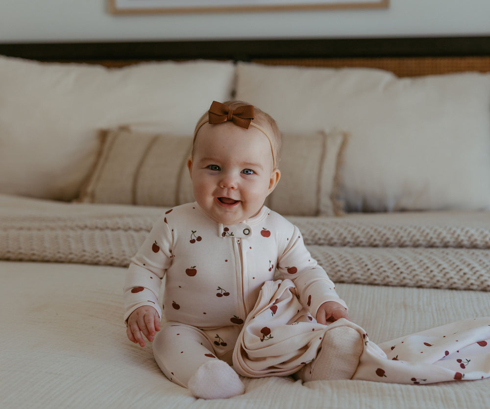 Child wearing Organic 2-Way Zipper Footie in Cherry Apple.