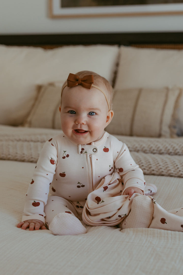 Child wearing Organic 2-Way Zipper Footie in Cherry Apple.