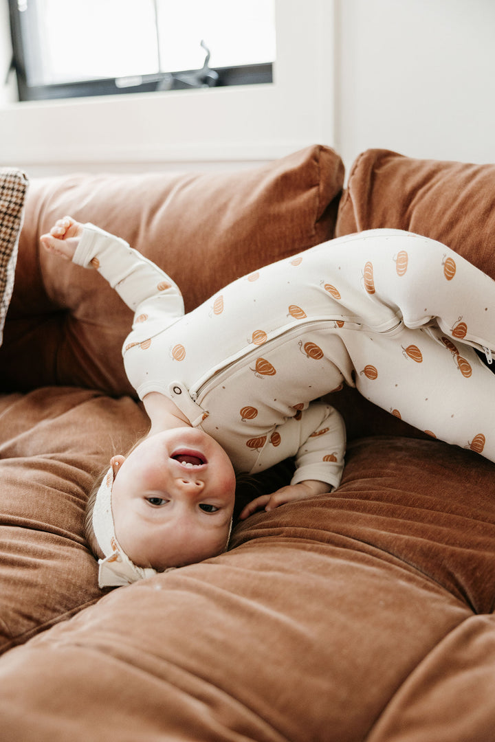 Child wearing Organic 2-Way Zipper Footie in Pumpkin Spice.