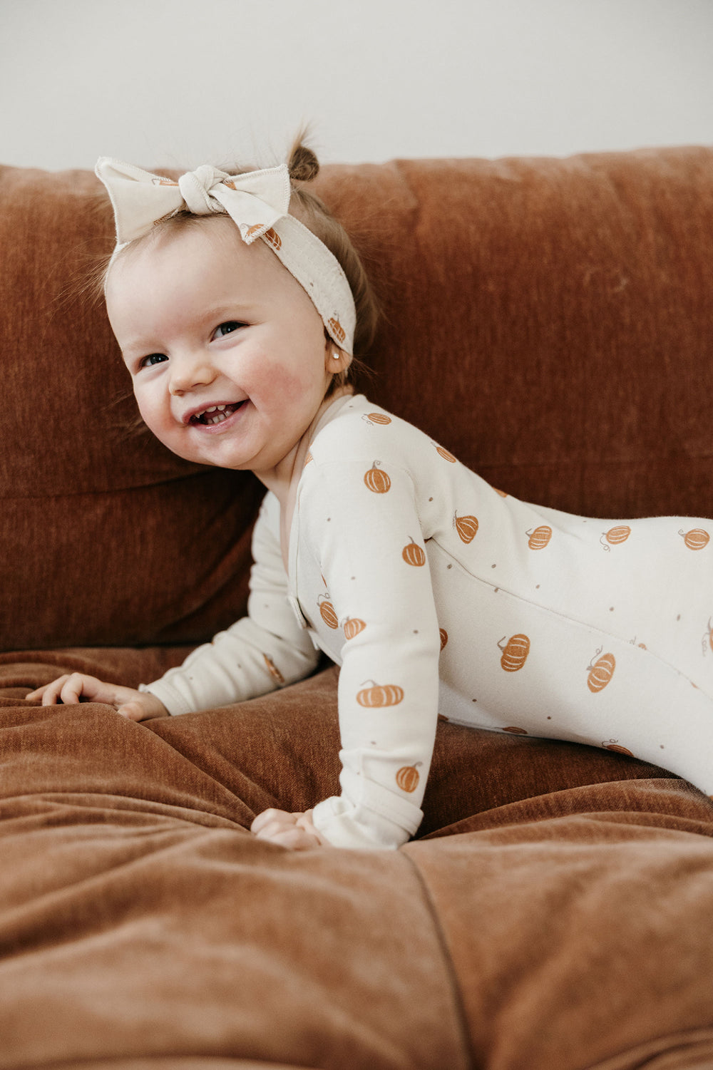 Child wearing Organic Smocked Tie Headband in Pumpkin Spice.