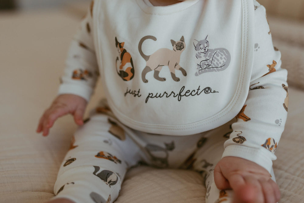 Child wearing Organic Reversible Bib in 9 Lives.