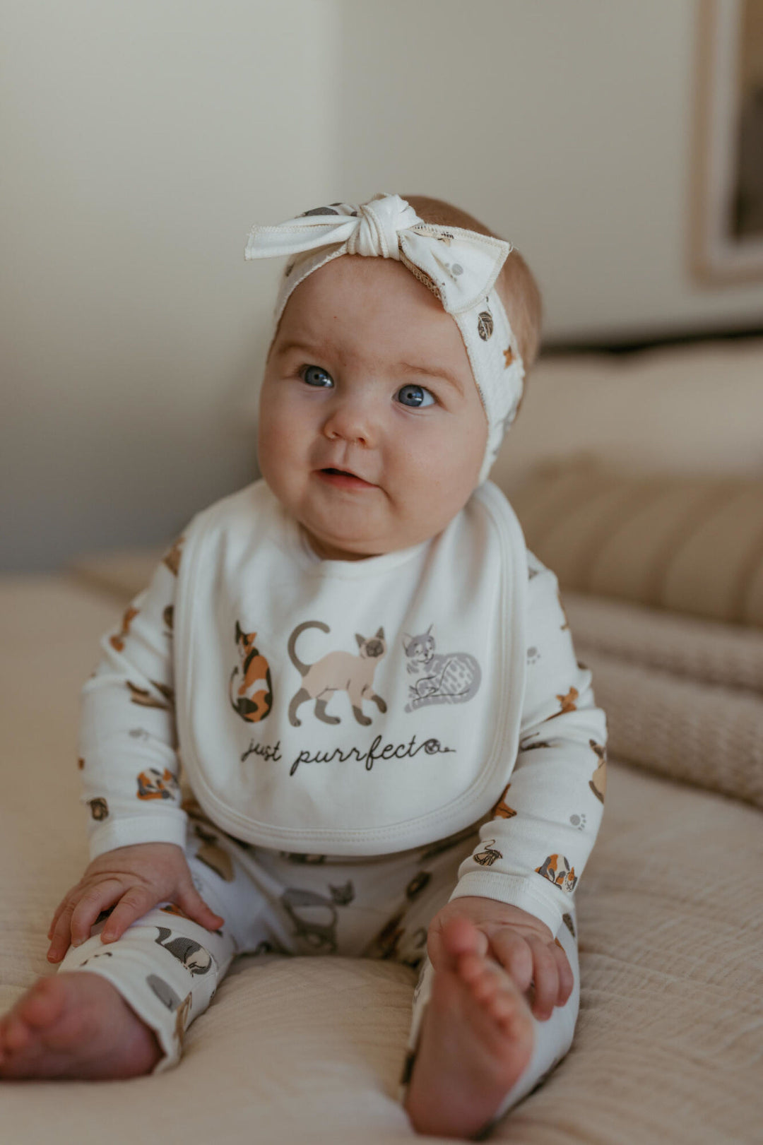 Child wearing Organic Reversible Bib in 9 Lives.
