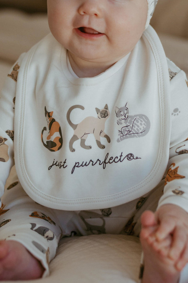 Child wearing Organic Reversible Bib in 9 Lives.