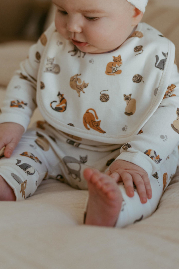 Child wearing Organic Reversible Bib in 9 Lives.