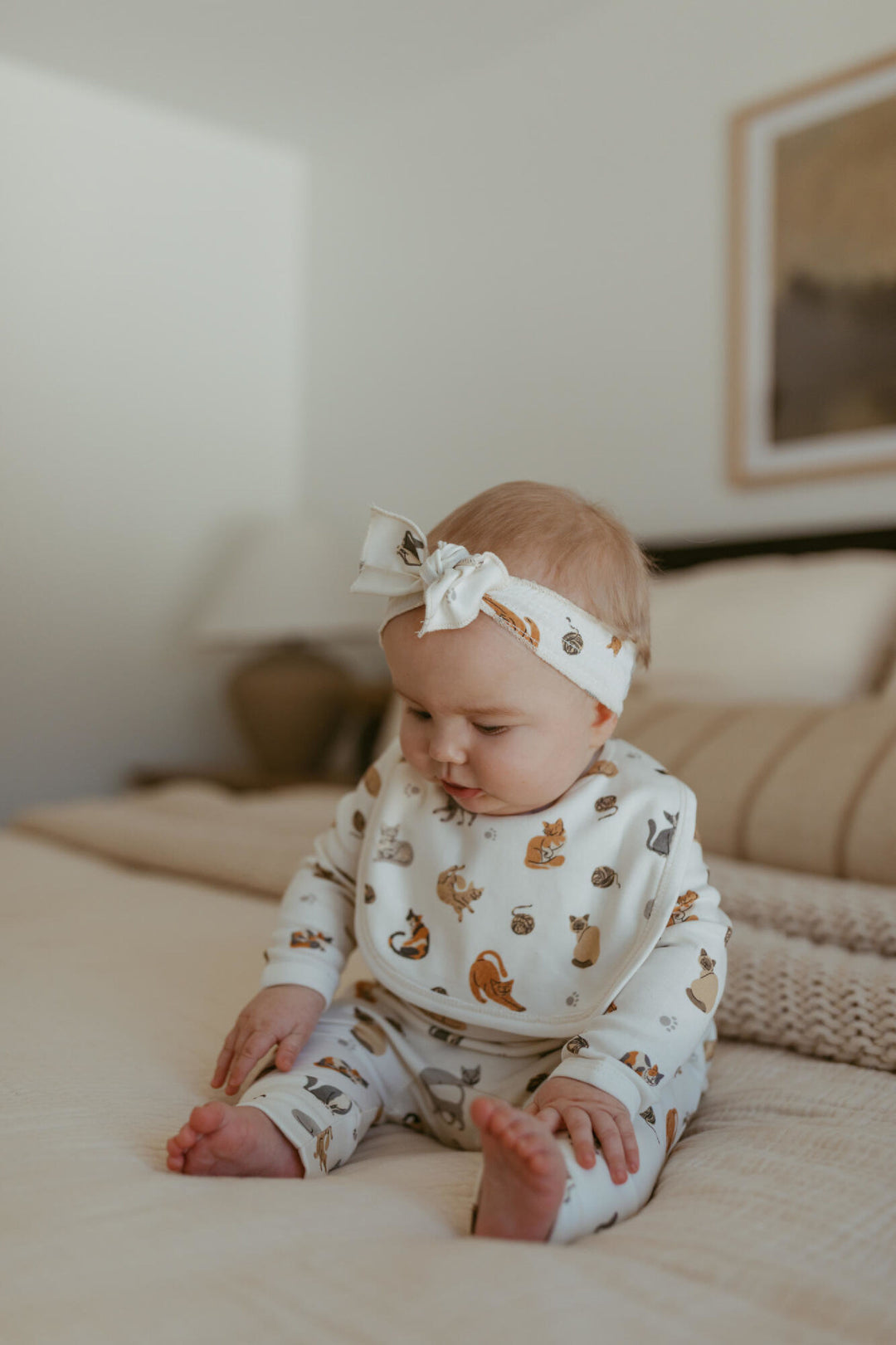 Child wearing Organic Reversible Bib in 9 Lives.