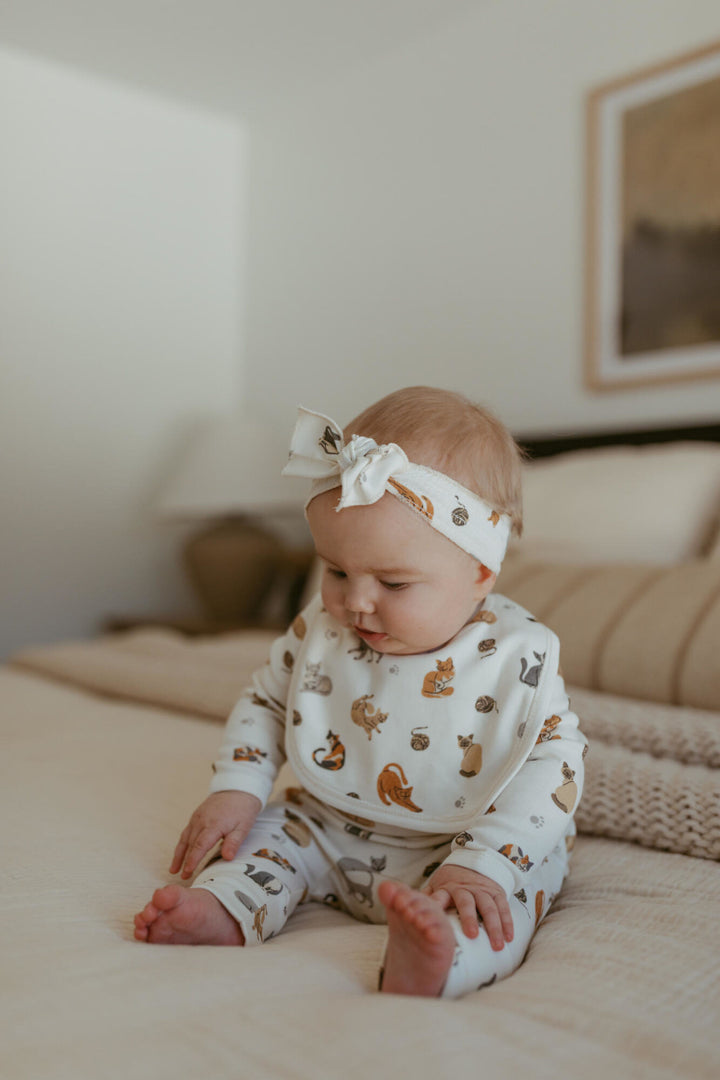 Child wearing Organic Reversible Bib in 9 Lives.
