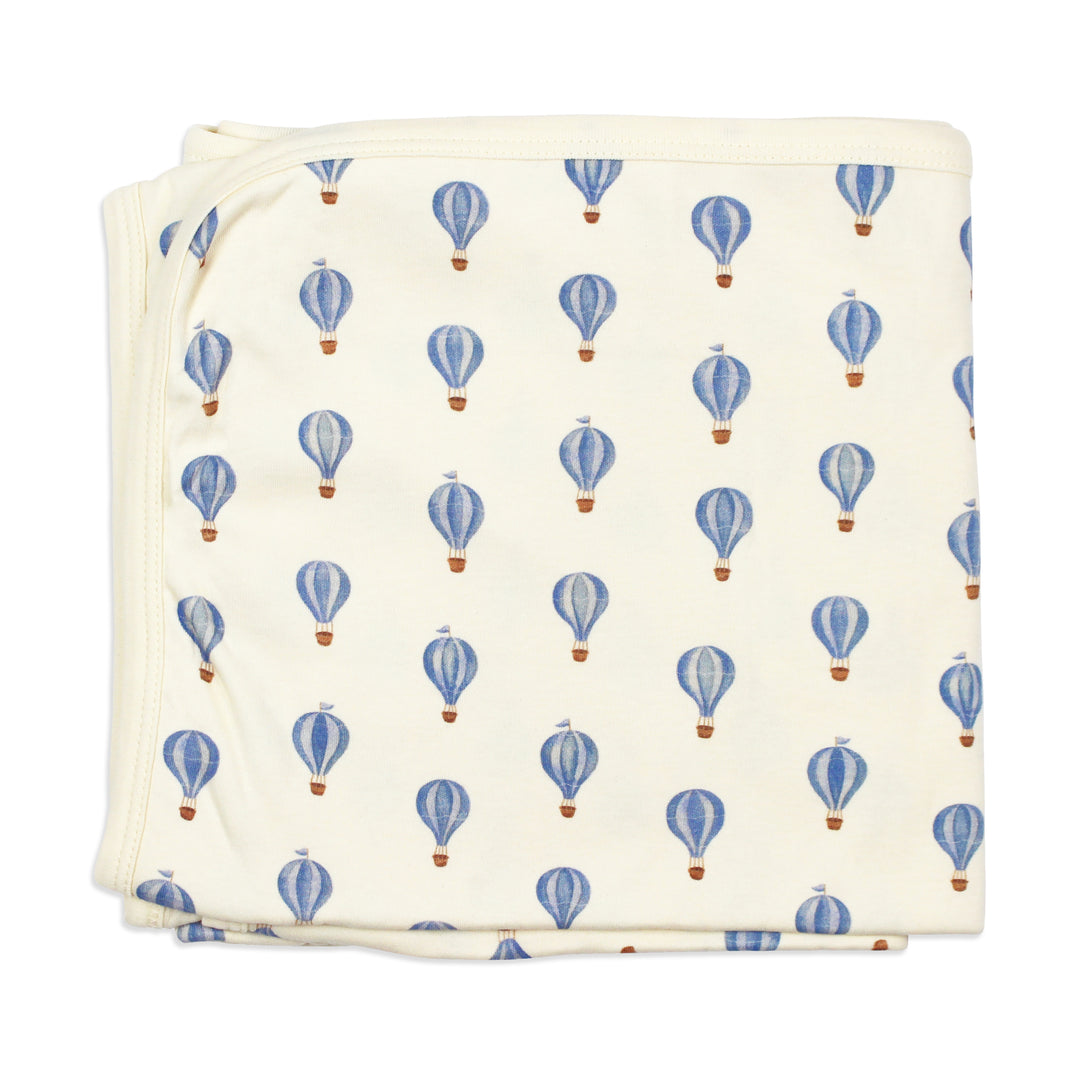 flat image of folded swaddle blanket in blue hot air balloon print