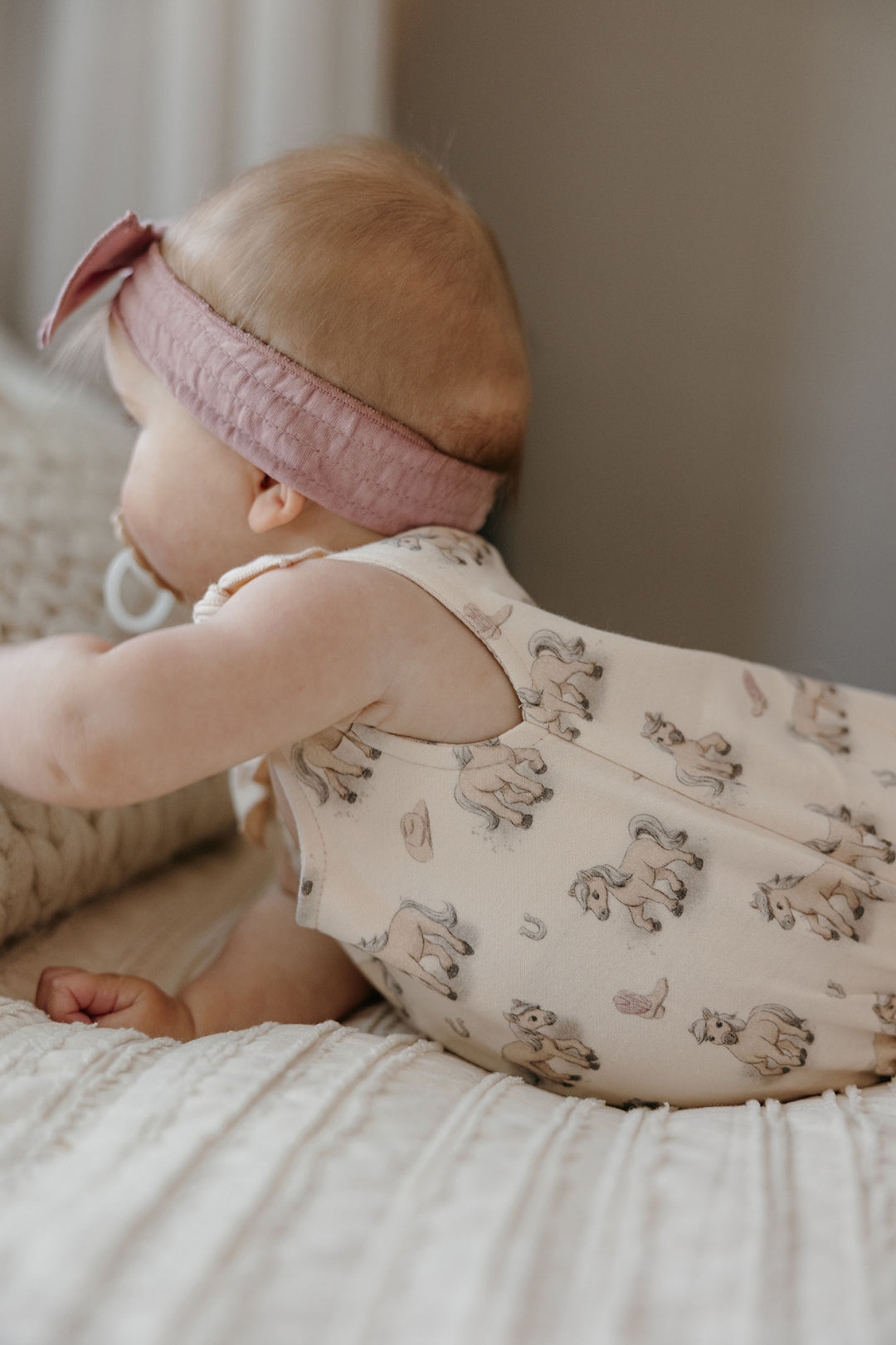 Child wearing Organic Bowtie Shoulder Bodysuit in Blush Boots.