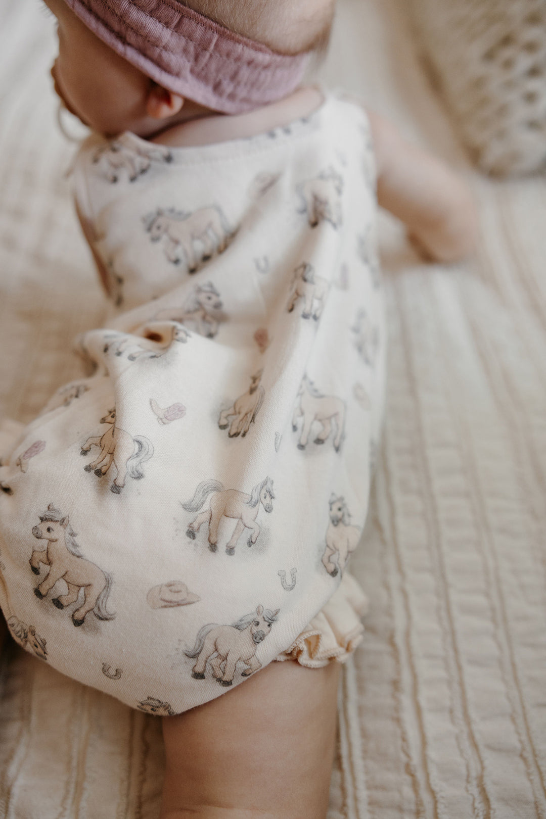 Child wearing Organic Bowtie Shoulder Bodysuit in Blush Boots.