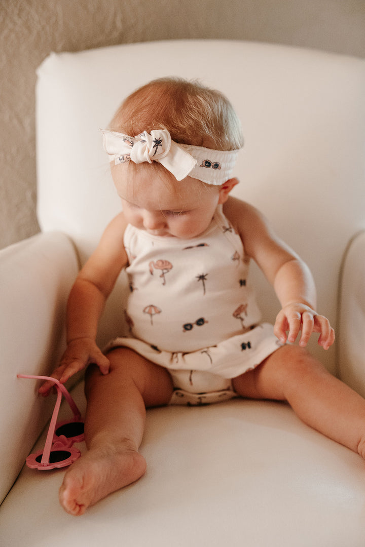 Child wearing Skirted X-Back Bodysuit in Flamingo.