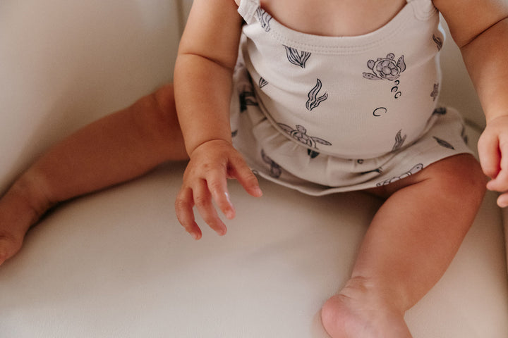 Child wearing Skirted X-Back Bodysuit in Sea Turtle.