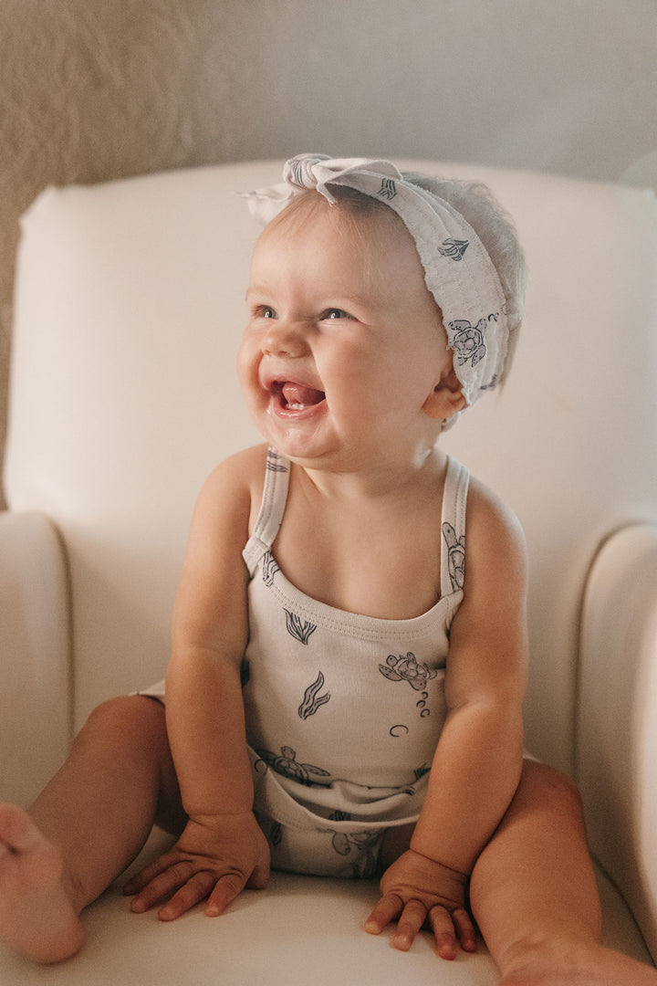 Child wearing Skirted X-Back Bodysuit in Sea Turtle.