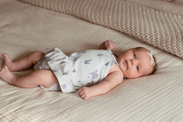 Child wearing Skirted X-Back Bodysuit in Sea Turtle.