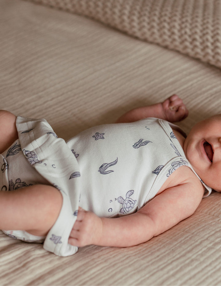 Child wearing Skirted X-Back Bodysuit in Sea Turtle.