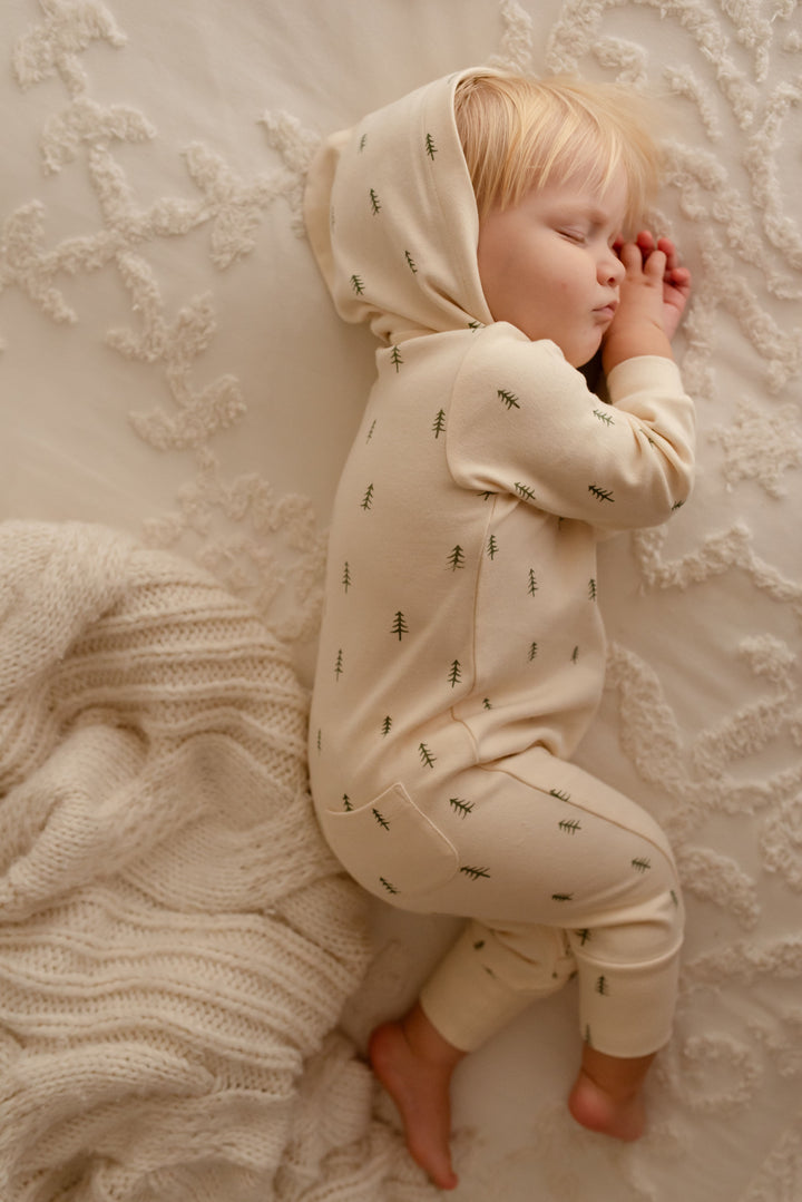 Child wearing Organic Zipper Romper in Buttercream Tree.
