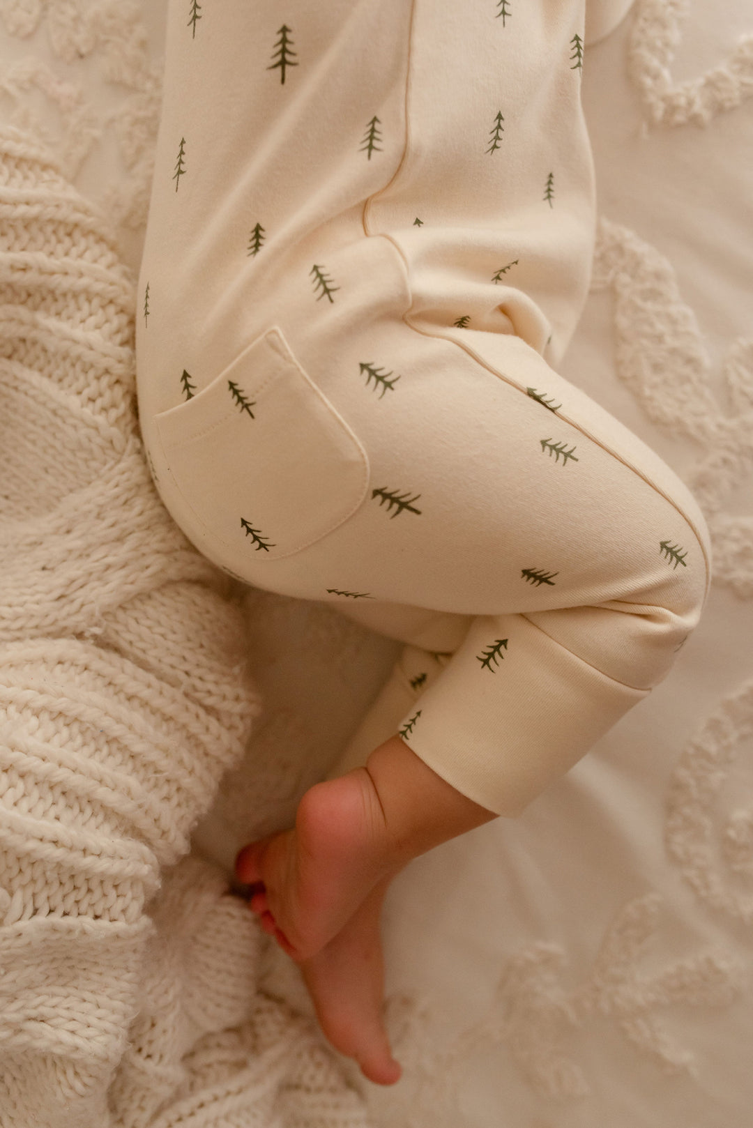 Child wearing Organic Zipper Romper in Buttercream Tree.