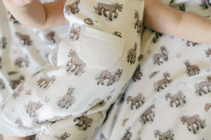 Child wearing Organic Sleeveless Romper in Little Lasso.