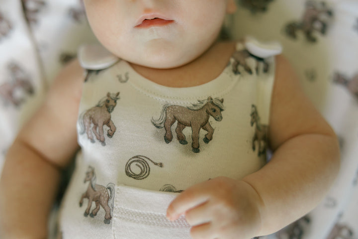 Child wearing Organic Sleeveless Romper in Little Lasso.