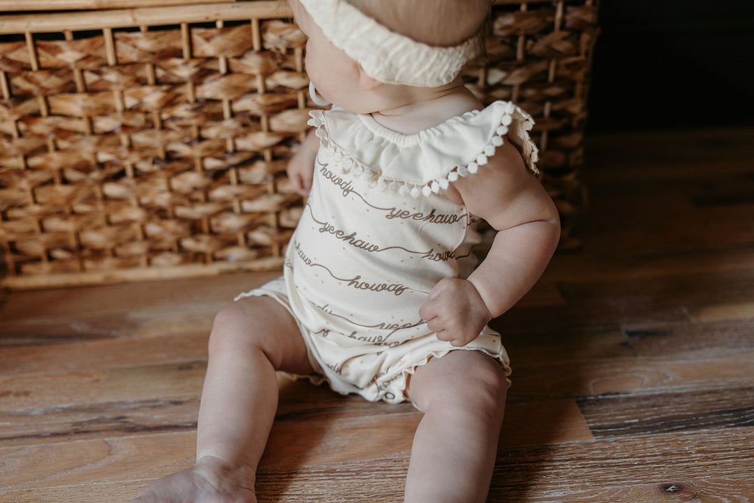 Child wearing Organic Bubble Romper in Howdy.