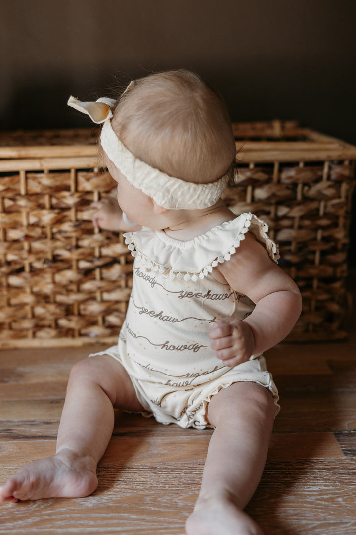 Child wearing Organic Bubble Romper in Howdy.