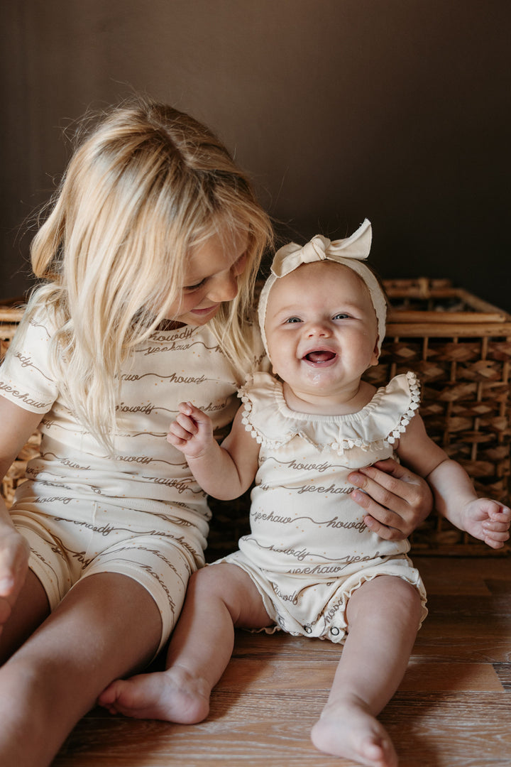 Child wearing Organic Bubble Romper in Howdy.