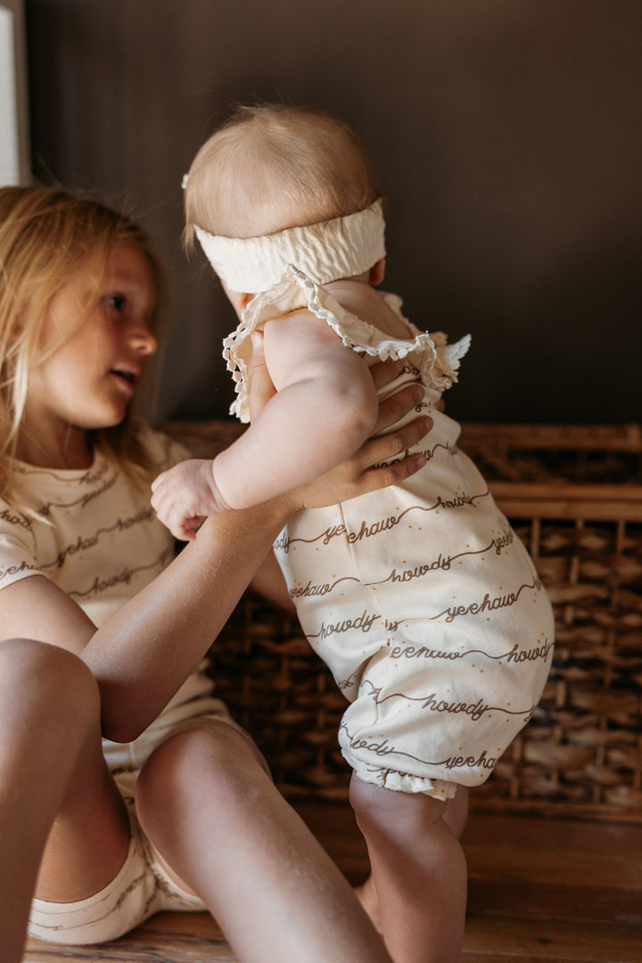 Child wearing Organic Bubble Romper in Howdy.