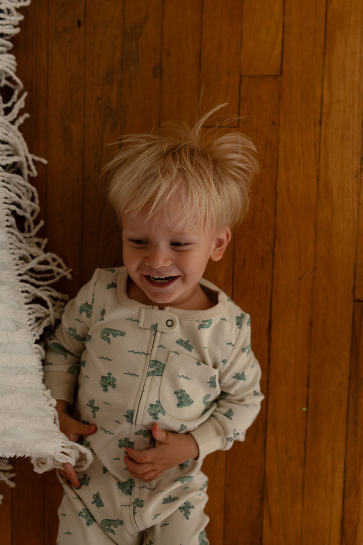 Child wearing Organic Footless 2-Way Zipper Romper in Alligator.