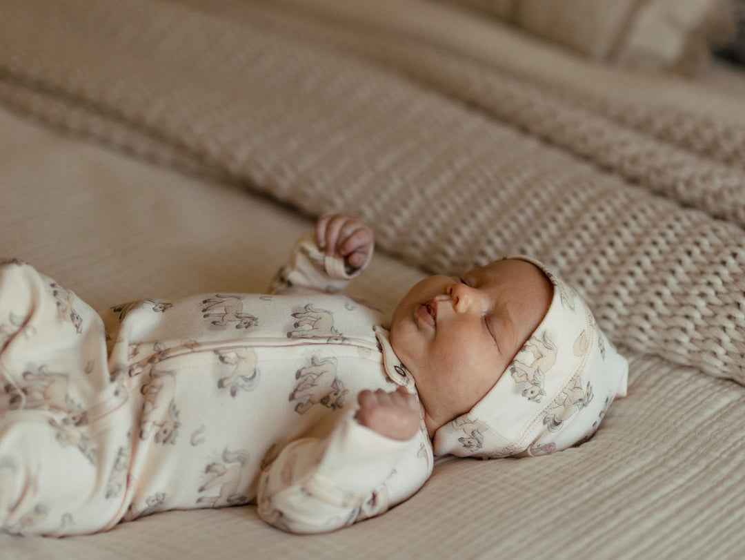 Child wearing Organic 2-Way Zipper Footie in Blush Boots.