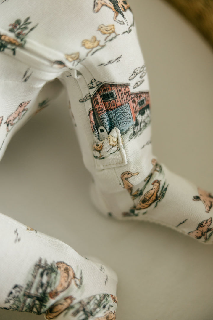 Child wearing Organic 2-Way Zipper Footie in Farm Friends.