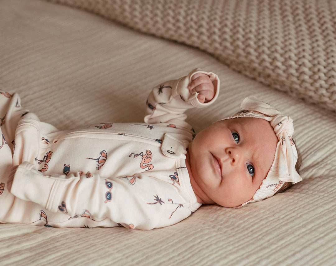 Child wearing Organic 2-Way Zipper Footie in Flamingo.