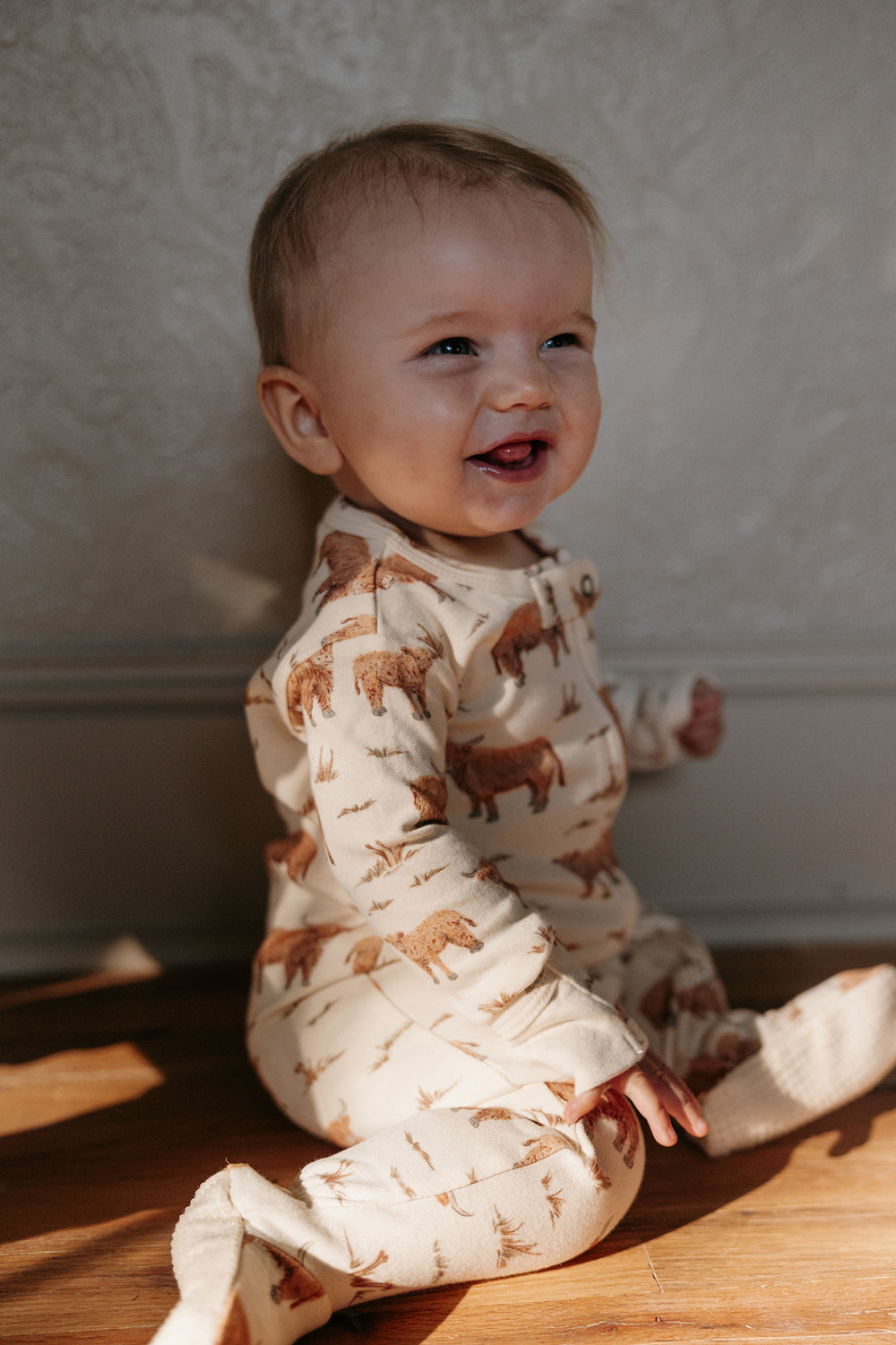 Child wearing Organic 2-Way Zipper Footie in Highland Cow.