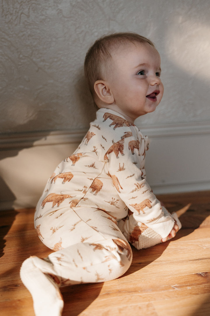 Child wearing Organic 2-Way Zipper Footie in Highland Cow.