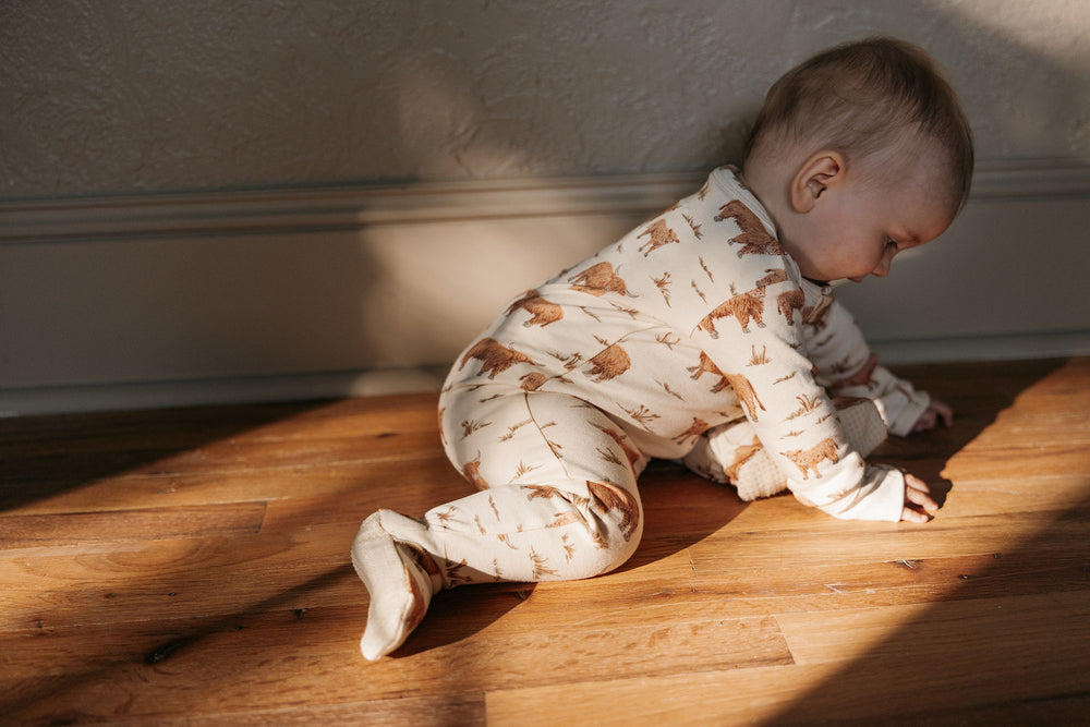 Child wearing Organic 2-Way Zipper Footie in Highland Cow.