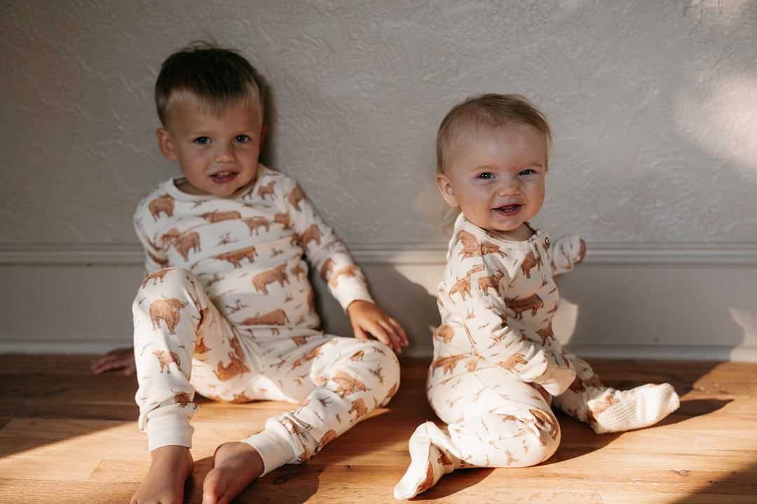 Child wearing Organic 2-Way Zipper Footie in Highland Cow.