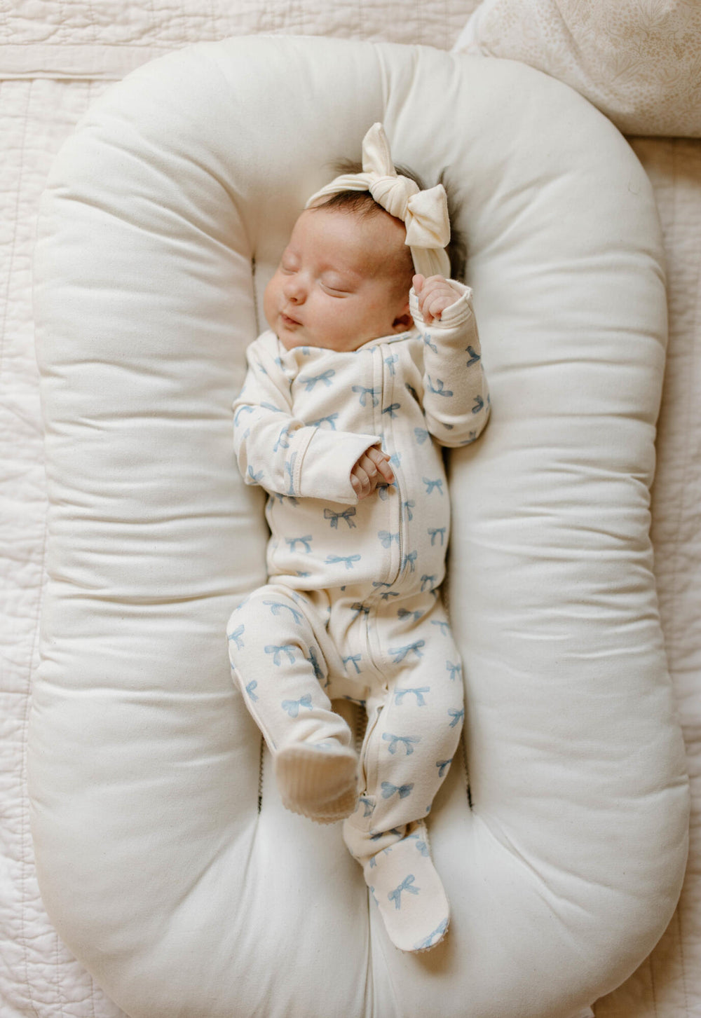 Baby footie with blue bow pattern on a white background
