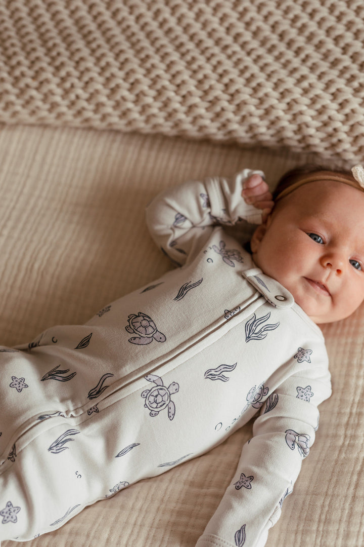 Child wearing Organic 2-Way Zipper Footie in Sea Turtle.