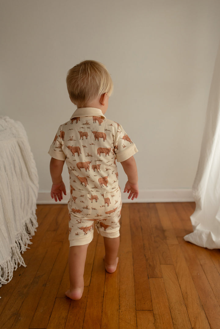 Child wearing Organic S/Sleeve Coverall in Highland Cow.
