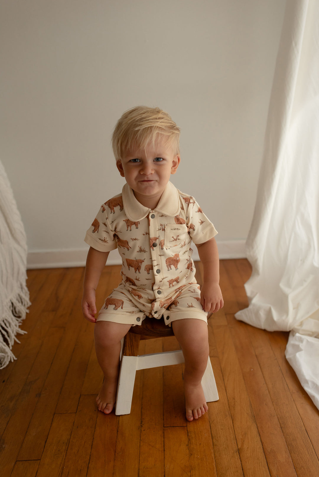 Child wearing Organic S/Sleeve Coverall in Highland Cow.