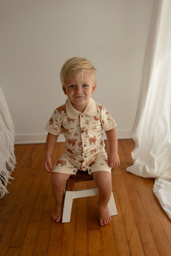 Child wearing Organic S/Sleeve Coverall in Highland Cow.