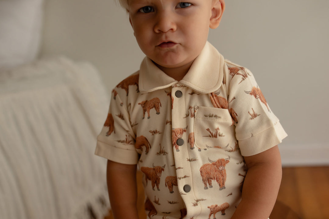 Child wearing Organic S/Sleeve Coverall in Highland Cow.