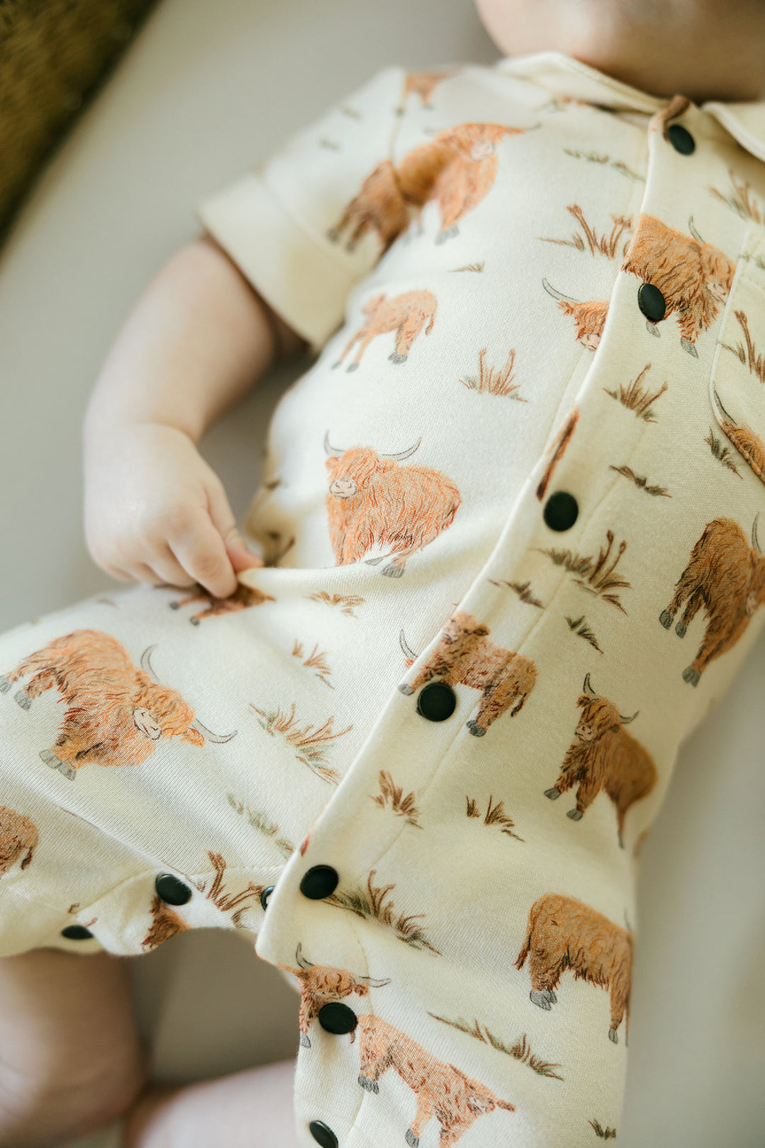 Child wearing Organic S/Sleeve Coverall in Highland Cow.