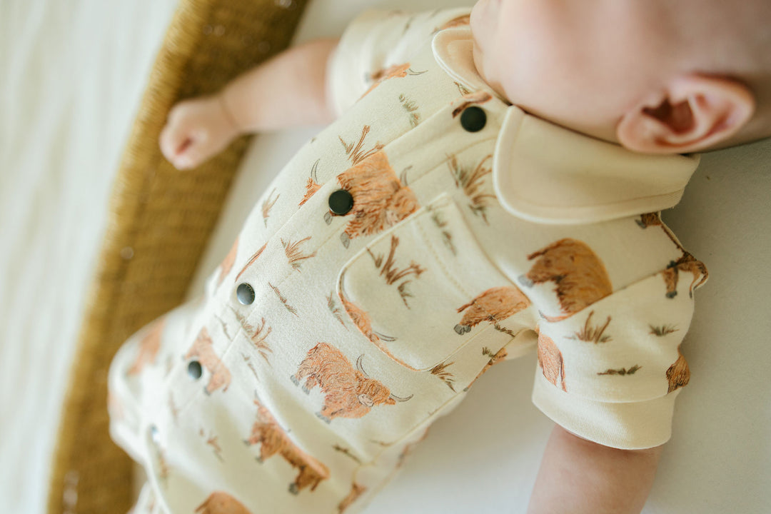 Child wearing Organic S/Sleeve Coverall in Highland Cow.