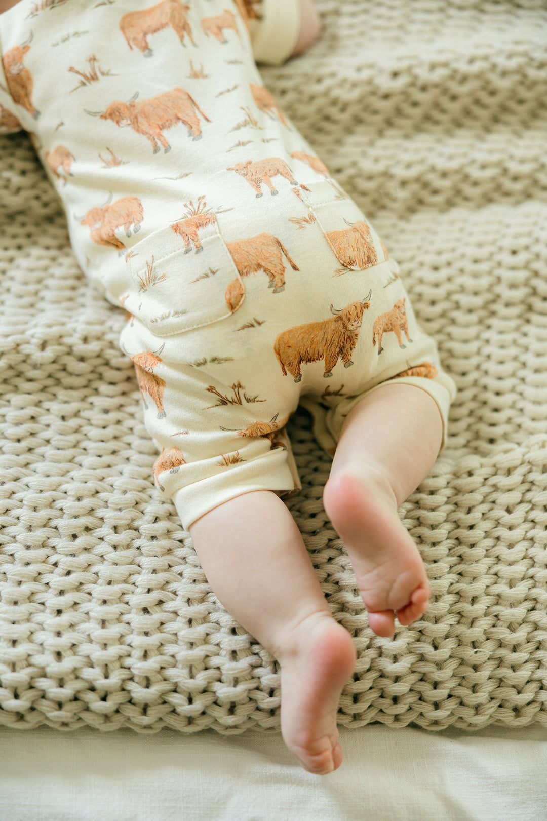 Child wearing Organic S/Sleeve Coverall in Highland Cow.
